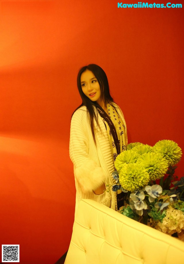 A woman standing next to a bunch of flowers.