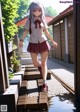 A girl in a school uniform is walking down a path.