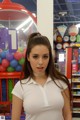 A woman standing in front of a candy store.