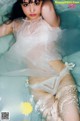 A woman in a white lingerie laying in the water.