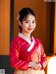 A woman in a red and white hanbok poses for a picture.