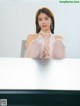 A woman sitting on top of a white table.