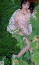 A woman in a floral dress laying in the grass.