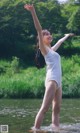 A woman in a white bathing suit standing in the water.