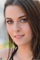 A beautiful young woman with long brown hair posing for a picture.