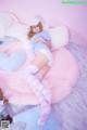 A woman laying on top of a bed next to a teddy bear.